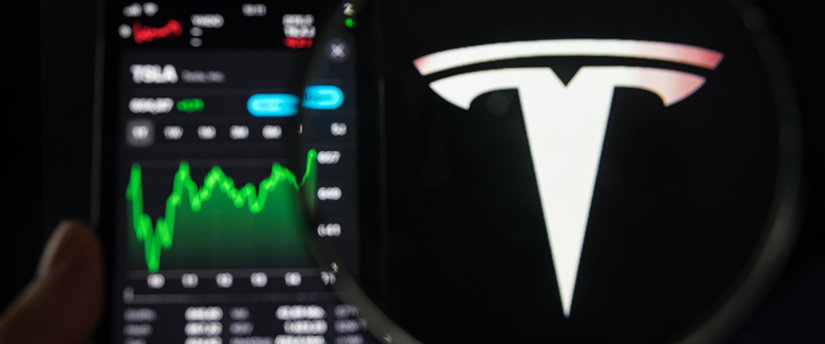 the Tesla symbol next to a mobile screen showing the price of the Tesla (TSLA) stock