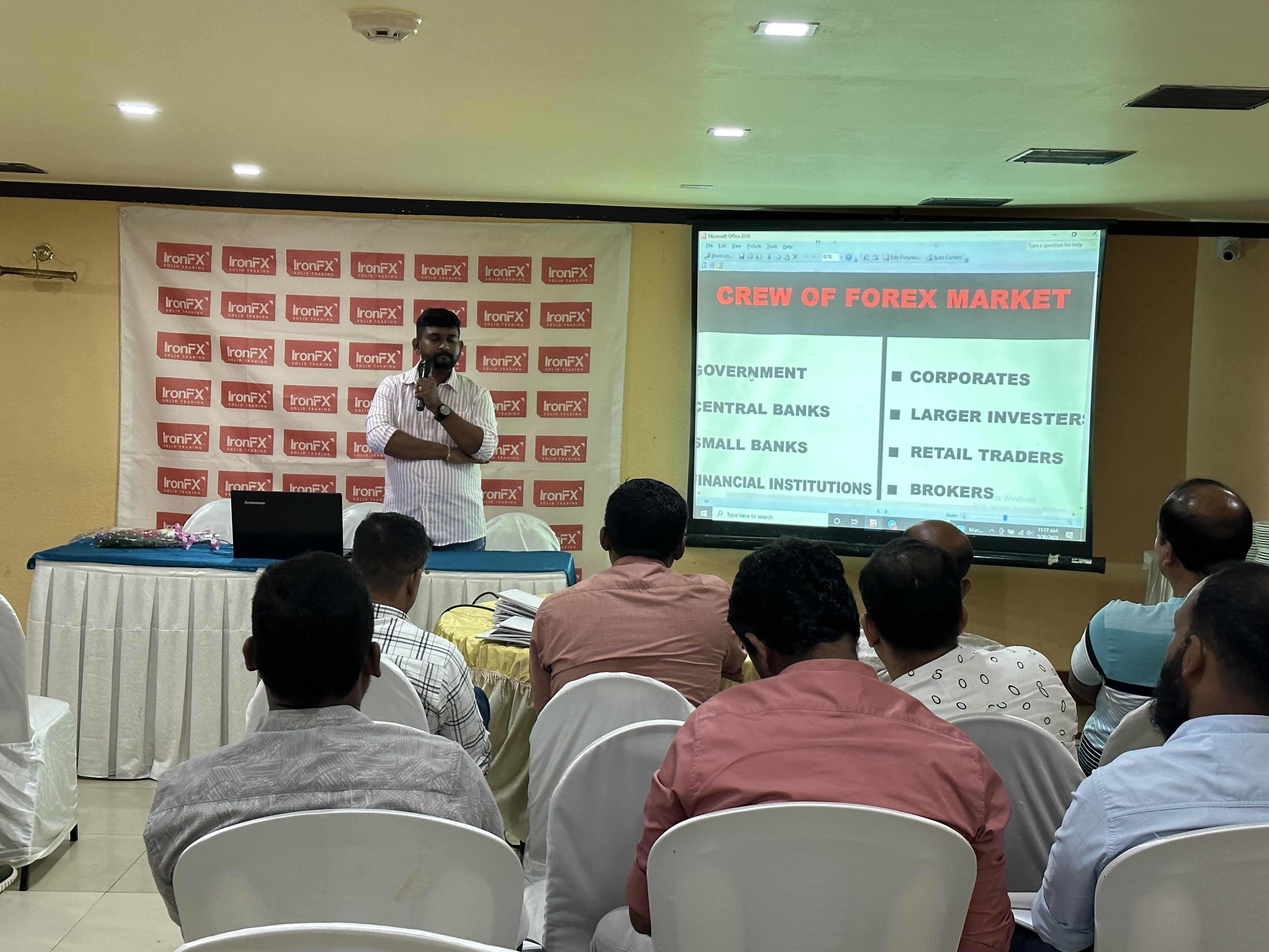 A man presenting to a group of people in a conference room.