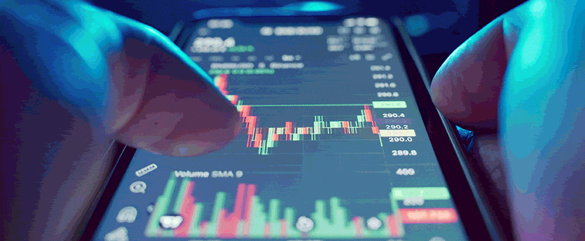 A person holding a smartphone displaying a stock market chart, providing forex trading tips to mobile traders
