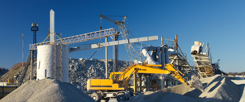 A construction site featuring a large crane towering over a substantial pile of sand, indicating ongoing building activities.
