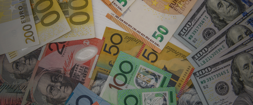 A diverse stack of banknotes from various currencies, showcasing different colors and designs.